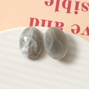 Gros plan de cabochons en résine ovale avec texture marbre gris pour bijoux DIY