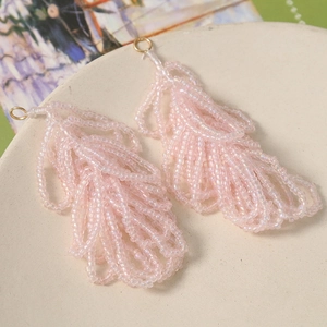 Detailansicht von handgefertigten rosa Perlenfeder-Anhängern für DIY-Schmuck