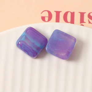 Macro shot of 16mm square resin charms with blue-purple marble smoke and gold glitter