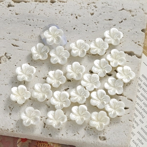 Detail of 11mm pearlescent white resin flower charms for DIY nail art and handicrafts