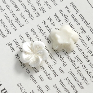 Macro shot of 11mm pearlescent white orchid nail art charms with intricate petal textures