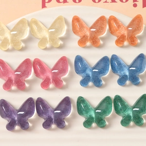 Close-up of 12 colorful resin butterfly charms with glitter texture for DIY jewelry making