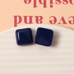 Macro detail of 15mm navy blue square resin stud earrings with a high gloss finish