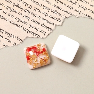 Close-up of resin square charm with gold foil and dried flowers for DIY jewelry making