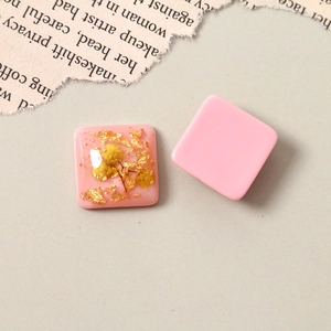 Flat lay of square resin charms with gold foil, dried flowers, and matte pink finish