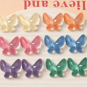 Macro detail of translucent glitter resin butterfly charms for DIY jewelry and hair accessories