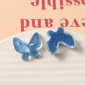 Macro view of blue butterfly resin charms with glitter effect for DIY jewelry and hair clips