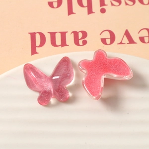 Macro shot of glittery pink resin butterfly accessories for DIY jewelry and crafts