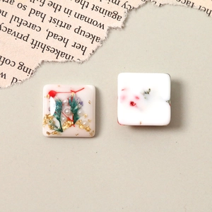Detail of square resin charms with gold foil, dried flowers and pearls for DIY jewelry