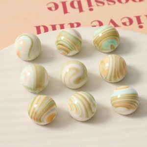 Détail macro de perles sphériques en résine à rayures colorées pour bijoux artisanaux