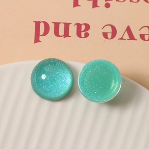 Macro view of 20mm green starry glitter resin cabochons for DIY jewelry making