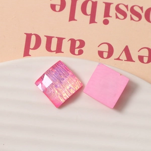 Dettaglio di ciondoli quadrati in resina rosa da 15mm con finiture glitter e opache per fai-da-te