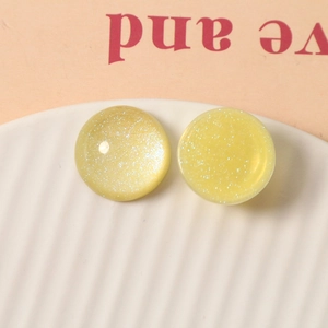 Macro view of 20mm yellow resin round cabochon with silver glitter for DIY jewelry crafts
