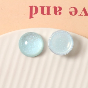 Macro detail of 20mm translucent glitter resin cabochons in blue and mint green colors
