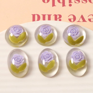 Flat lay of 3D resin flower cabochons with purple roses for DIY jewelry making