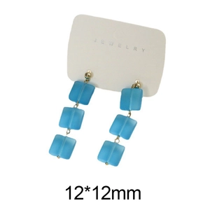 Dettaglio di perline quadrate in vetro azzurro opaco da 12 mm su orecchini a pendente