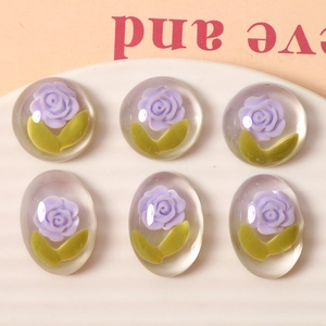 Macro detail of six oval resin charms featuring purple roses for DIY jewelry making