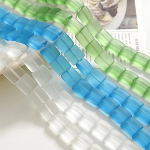 Dettaglio macro di perline di vetro smerigliato da 12mm in verde, blu e trasparente DIY