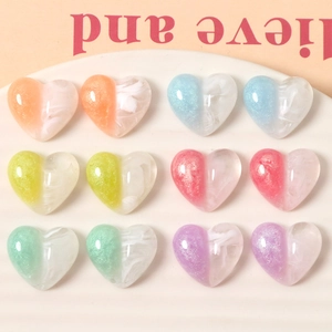 Colorful resin heart charms with glitter and marble texture in a striped tray