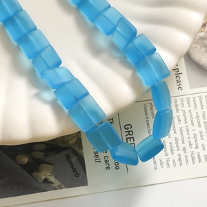 Dettaglio macro di perline di vetro blu satinato su vassoio a conchiglia per gioielli DIY