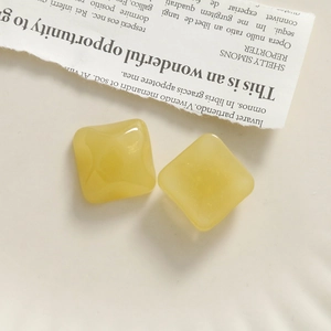 Macro view of square yellow resin charms with glossy finish for DIY jewelry crafts