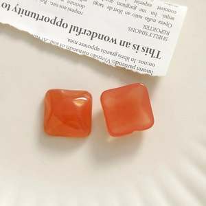 Detail of orange resin square charms with gold glitter for DIY earring and hair clip making