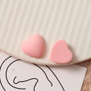 Detail van matte roze hartvormige bedeltjes van hars met matte textuur voor sieraden
