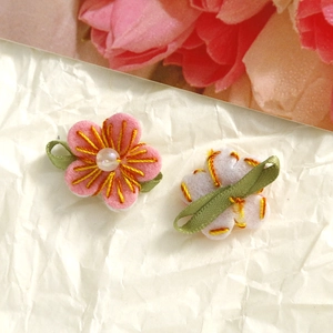 Detailed view of handmade pink felt flower with pearl center and green ribbon loop