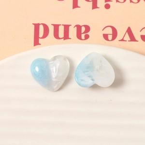 Close-up of blue and white gradient heart-shaped resin charms with glitter detail