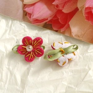 Detailed close-up of handmade felt flower charms with embroidery and bead for DIY crafts