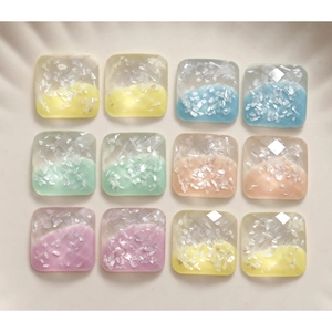 Macro detail of square faceted resin cabochons with shimmery shell inlay for DIY crafts