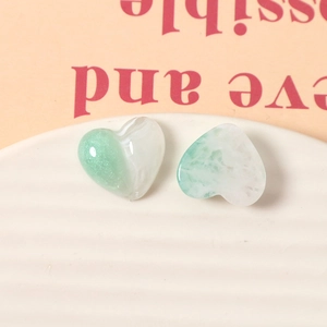Detailed view of heart-shaped resin charms with green marble texture and fine glitter