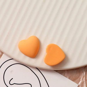 Macro-opname van matte oranje hartvormige bedeltjes voor DIY-sieraden maken