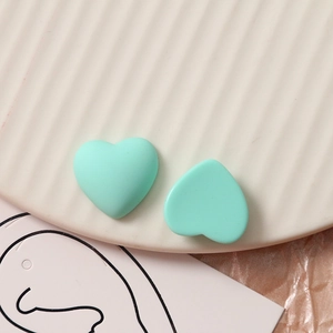 Macro-detail van twee muntgroene mat-hars hartbedeltjes voor DIY-sieraden maken