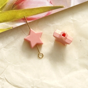 Macro detail of 10mm pink star acrylic bead with hole for DIY jewelry making
