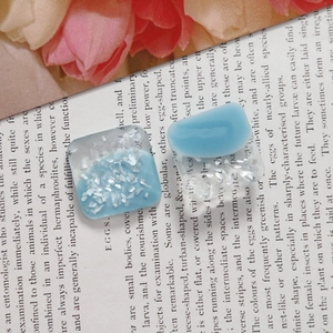 Macro detail of square blue resin charms with shimmering sequins for DIY jewelry making