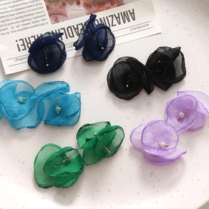 Detail van handgemaakte organza bloemblaadjes hangers met parels in vijf levendige kleuren