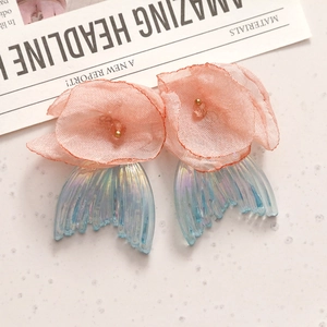 Detail van roze gaasbloem en blauwe iriserende vissenstaart hanger voor DIY oorbellen
