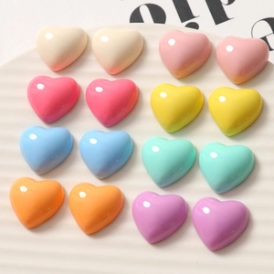Set of sixteen colorful glossy resin heart charms in mixed pastel tones on a white tray