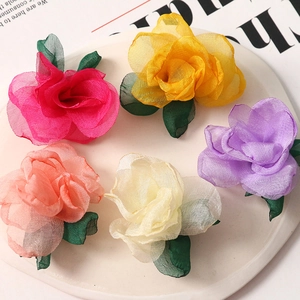 Close-up of five colorful soft mesh fabric flower charms with green leaves for DIY crafts