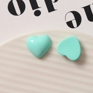 Glossy mint green resin heart charms for DIY jewelry on a white ceramic tray