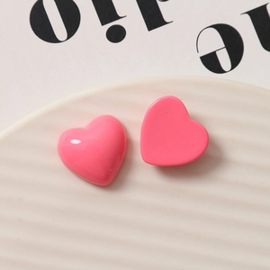 Macro shot of peach pink heart resin charms with a glossy finish for jewelry making