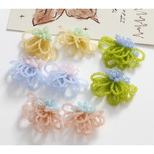 Handmade woven floral bead earrings in various pastel colors on a minimal background