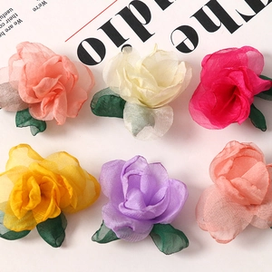 Detailed view of colorful organza rose fabric flowers with green leaves for DIY hair accessories