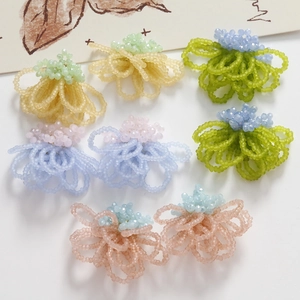 Macro view of handmade woven glass bead flower earrings in vibrant mixed colors