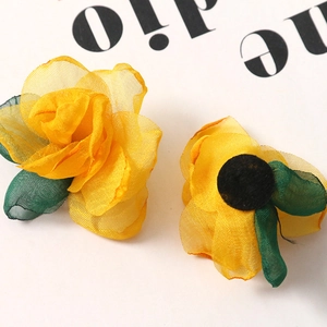 Close-up of yellow layered organza rose petals with green mesh leaves for DIY crafts