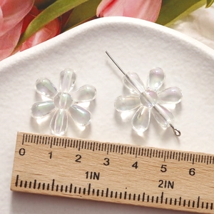 Macro view of transparent iridescent flower resin beads with 20mm diameter size reference
