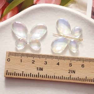 Macro detail of iridescent 30mm butterfly resin charms with Aurora AB coating for jewelry diy