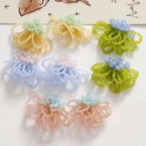 Macro shot of handmade beaded flower charms in various colors for DIY jewelry making