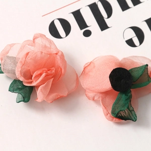 Macro detail of delicate sheer fabric silk petals and green leaves for DIY hair accessories